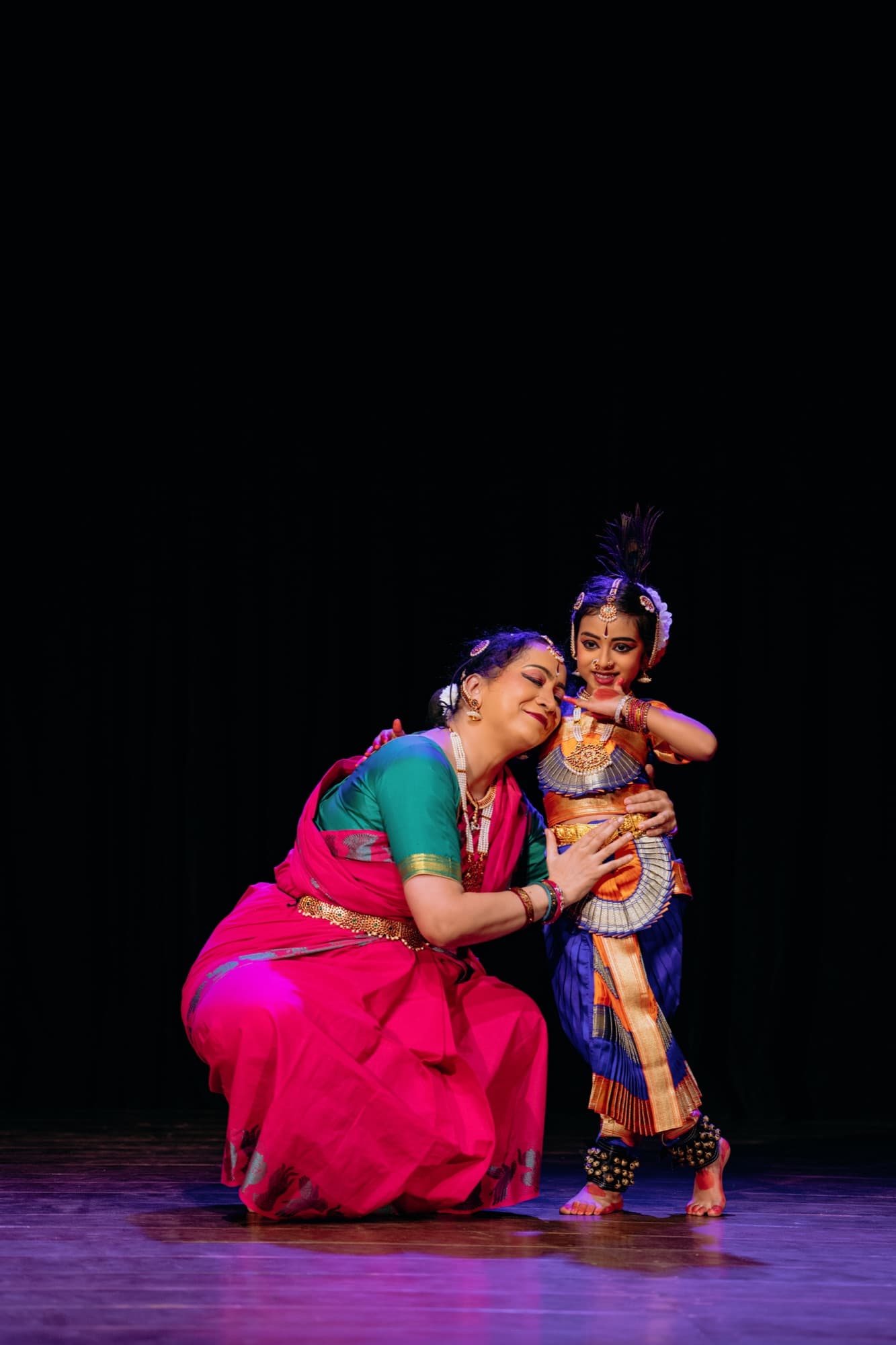 A teacher embracing a young student after a performance